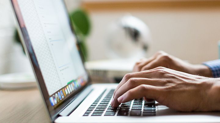 Person tippt auf Laptoptastatur.